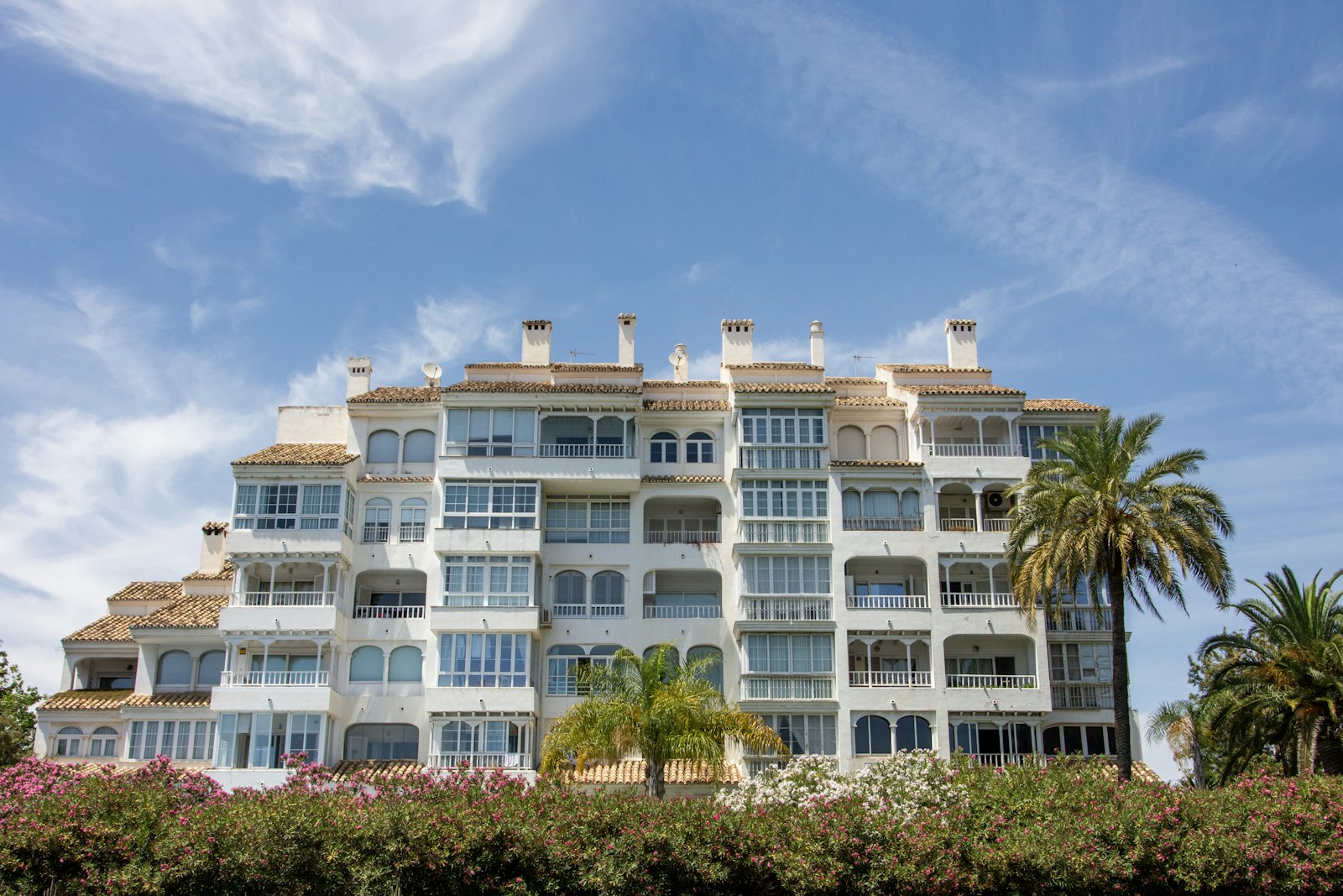 Edificio residencial con balcones y palmeras en la costa mediterránea española